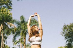 woman with arms up in the air, stretching in the sun